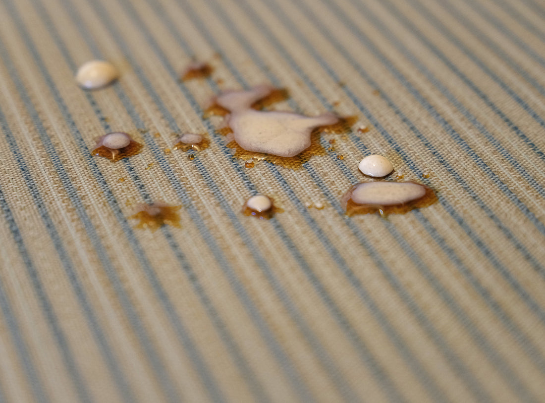 Passatoia Cucina Genia Beige con macchie d'acqua, dimostrando resistenza alle macchie e facilità di pulizia.