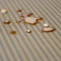 Passatoia Cucina Genia Beige con macchie d'acqua, dimostrando resistenza alle macchie e facilità di pulizia.